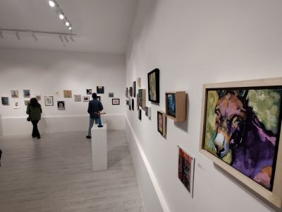 View of gallery with paintings on the wall and donkey painting in the foreground